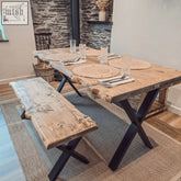 Rustic waney edge dining table with live edge wooden top and black x cross metal legs for stylish edge dining