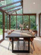 Dark wood live waney walnut colour edge dining table with black metal legs and dried flowers in glass vase centerpiece