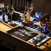 A bottle of superbox rosé wine with gold foil neck on a wooden coaster placed on lobster repeat slate place mats set of 2