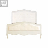 White double bed with tufted white upholstery, curved ornate legs, and matching headboard in Loire style