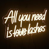A glowing white neon sign with all you need is love lashes in cursive for bedroom beauty girl room decor