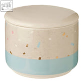A small fine earthenware grey blue jar with speckled beige body and colorful confetti pattern storage canister