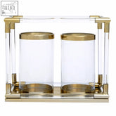 Gold-toned lucita double candle holder with clear acrylic bodies and brass accents for elegant decor
