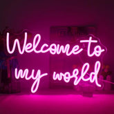 A glowing pink lucunstar neon sign with welcome to my world cursive text neon light for wall decoration