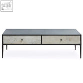 Modern minimalist luxor coffee table with sleek black top, textured off-white drawers, and slender black metal legs
