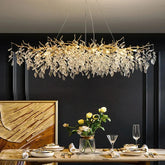 A golden branch-like chandelier with clear crystal leaves perfect as indoor villa lights fixture for elegant villa decor