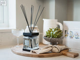 Clear glass luxury square diffuser fig citrine with black base and reeds holding dark liquid for home fragrance