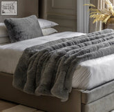 Luxxa grey faux fur throw is a plush medium-gray faux fur throw with a soft textured surface and ribbed folds