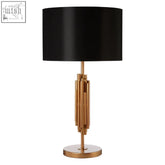 Black satin drum shade on a modern brass-finished manor table lamp with vertical cylindrical rods
