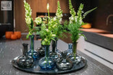 Set of seven mouth blown blue and dark glass vases with slender necks on black tray from dutz manuela vase set collection