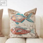 Beige marine cushion with embroidered orange red and teal fish on detailed fabric material with seaweed patterns