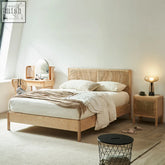 Light-colored mason king size bed with woven rattan headboard and footboard made of solid wood oak
