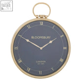 A classic gold-toned pocket watch design small wall clock with a dark blue face and bloomsbury london branding