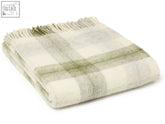 A meadow check pure new wool throw in cream and sage green plaid with textured weave and fringed edges