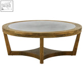 Merdeka coffee table with round alder wood top in light tones and dark brown rustic-finished legs with clear glass top