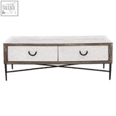 A rustic white-washed recycled elm coffee table with two drawers and black metal legs for stylish living spaces