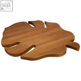 A smooth light brown wooden mimo leaf chopping board shaped like a monstera leaf with natural grain and cut-out veins