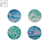 Set of four round cork coasters with teal blue and pink swirling marbled patterns perfect for drinks protection