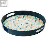 Mimo terrazzo round tray with glossy black rim and handles featuring pastel peach mint green and navy terrazzo pattern