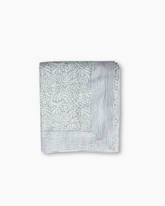 A soft light gray cotton square blanket with a delicate white leaf pattern and fine stripes featuring hand blocked printed design