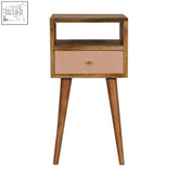 Mid-century modern nightstand with blush pink drawer and tapered legs made from solid mango wood frame