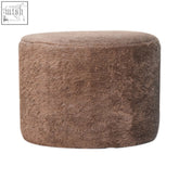 A mocha faux fur round footstool with a plush cylindrical shape and soft textured surface perfect for extra seating