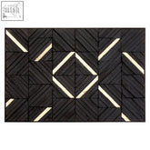Black wood carving wall art featuring a black and cream geometric mosaic tile mat with a herringbone pattern