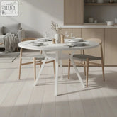 Modern white round dining table with minimalist pedestal base and lower shelf made of wood for round dining space