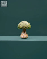 A moss mushroom figurine made of natural stone with preserved moss covering its textured earthy-toned cap and stem