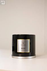 Black cylindrical 3 wick luxury candle with silver label and gold trim from li home musk scent in large candle collection