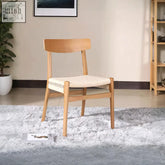 Light wood nadine rattan dining chair with woven cream seat and clean lines perfect for stylish dining areas