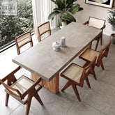 Concrete nakamura dining table with wooden legs and matching cane-backed chairs for stylish dining spaces