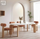 White oval namie dining table with light wood legs and matching terracotta upholstered chairs for cozy dining