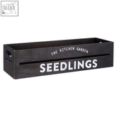 Black wood planter naresso with white lettering the kitchen garden and seedlings on a wooden herb crate