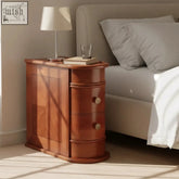 Warm-toned wooden narrow storage end table with two easy-glide curved drawers and decorative paneling
