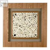 Nason framed lattice wall art featuring a square wooden frame with cream concrete panel and black circular cutouts