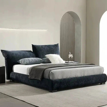 Navy blue velvet upholstered bed with a modern design and white bedding.