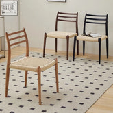 Three nehemiah dining chairs with slender wooden frames in natural dark brown and black and woven rattan seats