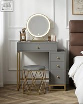 Gray nelia dressing table with gold-tone legs and drawer pulls featuring a round led illuminated mirror on top