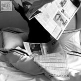 Black-and-white new yorker bundle newspaper with bold double black headlines and a photo of a person wearing glasses