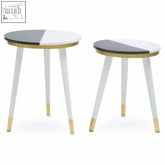Two minimalist side tables with black and half white marble tops and acacia wood legs with gold trim accents