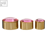 Set of three reflective gold trinket boxes with oval shapes and faceted pink lids for stylish storage