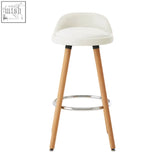 White bar stool normann with white upholstered seat, light wood legs, and chrome footrest for bar seating