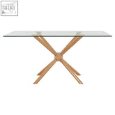 Modern rectangular rose gold dining table with clear glass top and light wood x-shape legs for stylish dining