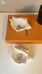White ceramic ocean trinket dish shaped like a seashell with a textured speckled finish and gold-toned detail inside