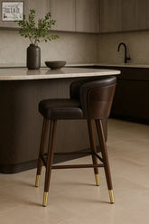 Dark brown leather okazaki bar stool with slender wooden legs and gold-tipped feet for stylish bar seating