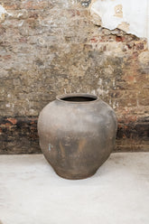 Old xl brown asian pots featuring a weathered dark gray ceramic jar with a rounded body and wide opening