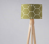 Olive green table lamp with hexagon design geometric lampshade on a light wood tripod base