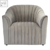 A plush grey velvet armchair with vertical pleats and rounded arms perfect for cozy seating