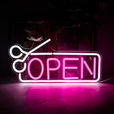 A glowing pink neon sign shaped like scissors cutting through the word open with a white outline usb powered open neon sign for shops